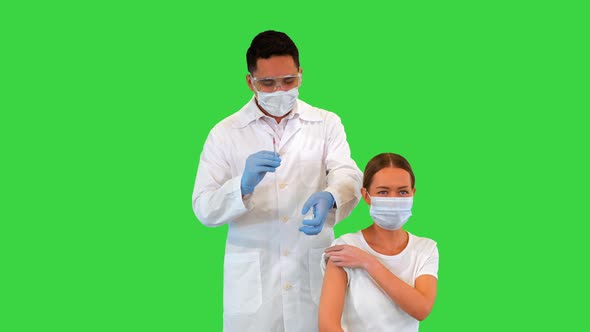 Doctor Making an Injection to Patient in a Medical Mask on a Green Screen Chroma Key