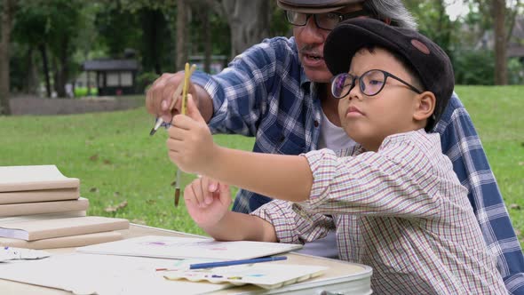 Senior man and boy learning artwork.