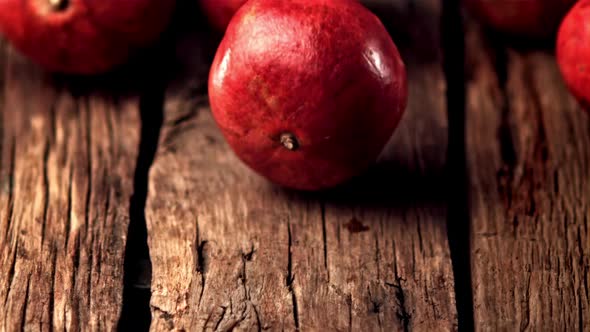 Super Slow Motion Ripe Pomegranats Roll Down Wooden Boards