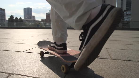 Legs of Man Skateboarding Over Scenic Cityscape