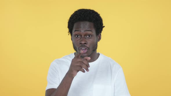 African Man Inviting Customers with Both Hands, Yellow Background