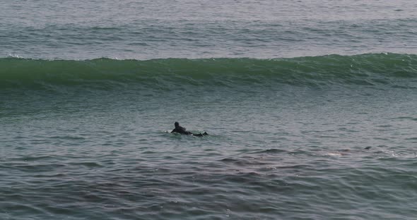 60FPS: Surfer paddles through breaking waves in perfect surf conditions - Smooth pan motion