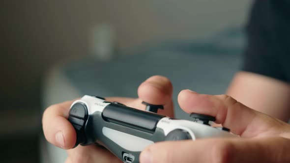 Closeup of the Hands of a Young Man Playing Video Games on a Game Console