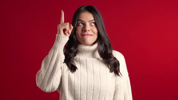 Portrait of Thinking Woman White Sweater Having Idea Moment Pointing Finger Up