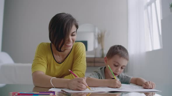 Young Woman And Child Drawing Together Making Picture With Pencils In Flat