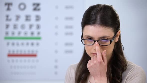 Attractive Woman Adjusting Eyeglasses and Smiling to Camera, Satisfied Patient