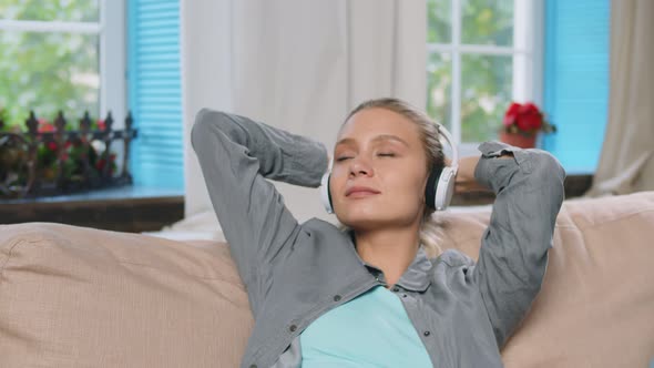 Young Beautiful Woman Listens To Music in Headphones