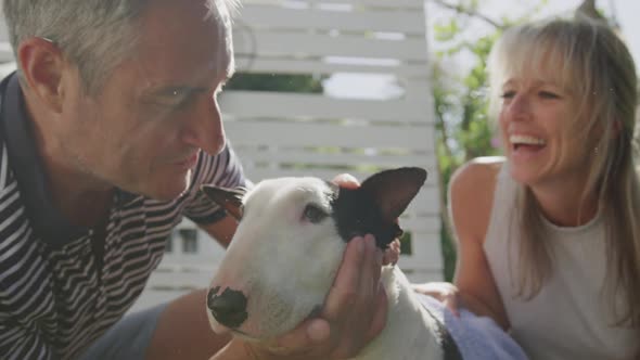 Couple washing dog in their garden