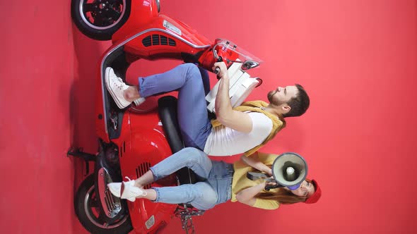 Young Man and a Woman Quickly Deliver Orders To Customers on a Scooter, They Sit on a Motorcycle