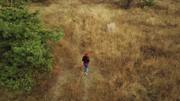 Aerial View of Woman Going on Ground with Dry Grass Alone in Countryside