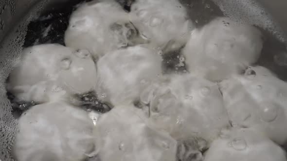 White Chicken Eggs Boiling in Stainless Steel Pan