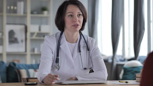 Old Lady Doctor Talking with Patient in Clinic