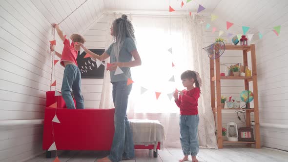 Children with Their Mother Decorate the Room for Halloween