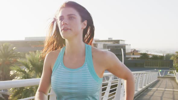 Young woman running on a bridge