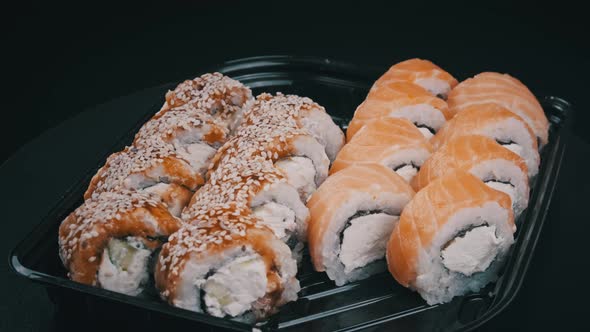 Sushi Rolls Rotating in Plastic Box