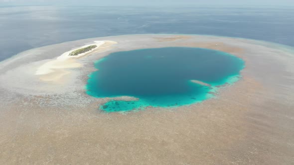 Aerial: Flying over idyllic atoll, travel destination Wakatobi National Park Ind