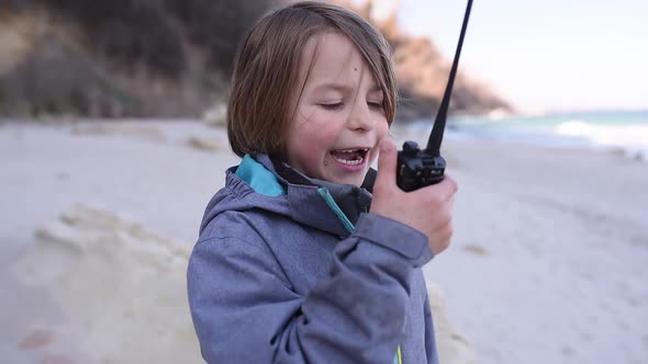 The Boy is Talking on the Radio on the Beach Outdoor