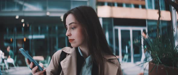 Woman sits and uses phone