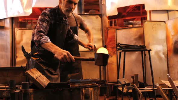 Glassblower shaping a molten glass