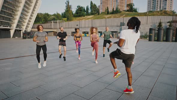 Multiracial Youth Group of Likeminded People Doing Warmup and Stretching in the Early Morning in the