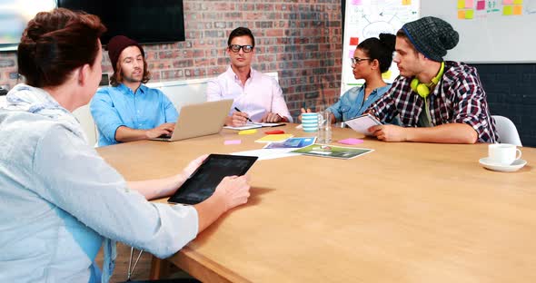 Businesspeople interacting while using laptop