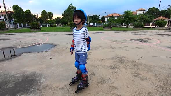 Asian Child Riding On Rollers In The Summer In The Park