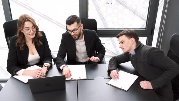 Three Coworkers Working on a Project at Office