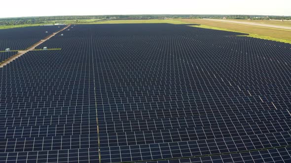 Top view of the power plant with solar panels. Beautiful green fields.