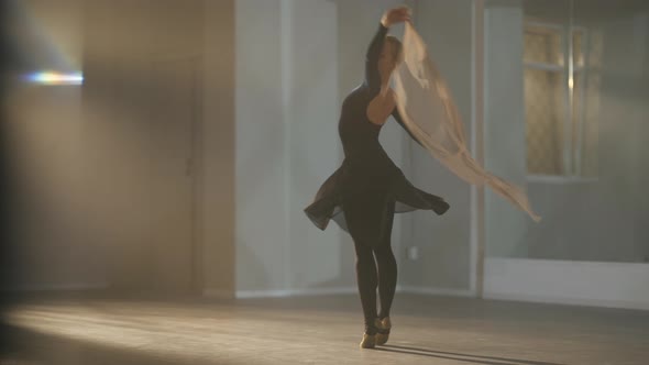 Talented Slim Gorgeous Ballerina Spinning on Tiptoes with Scarf in Hands in Backlit Fog in Slow