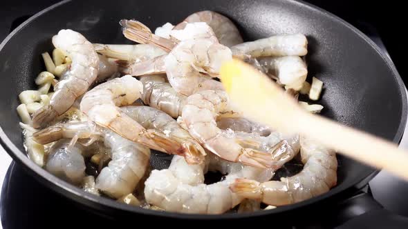 Adding Raw Prawns in a Pan with Garlic and Hot Olive Oil