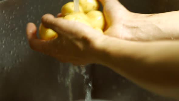 Male Hands Washing Potatoes.