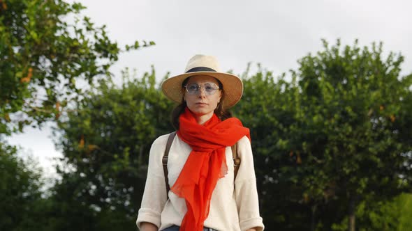 Serious girl with a red scarf looking at camera, outdoors