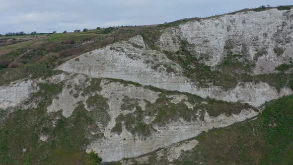 Descending drone shot of zig zag pathway on the side of white cliffs of dover