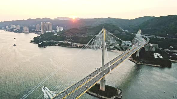 Boat cruises under Ting Kau bridge, Tsing Yi, Hong Kong; sunset aerial riser