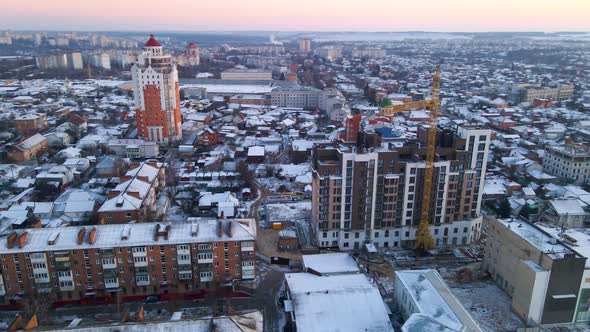 Aerial View of Drone Flying Over Building Construction in Small European City in Winter Cloudy Day