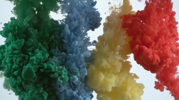 Slow motion shot of green, blue, yellow and red ink flowing into water, shot with Phantom Flex 4K ca alt