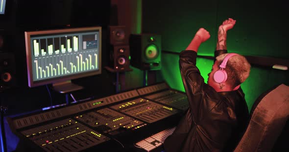 Female musicianengineer mixing new album inside boutique recording studio