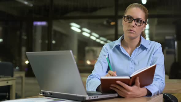 Young Businesswoman Writing Startup Ideas Into Notebook, Planning Meeting