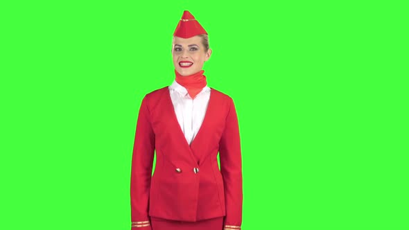 Stewardess in a Red Suit Winks a Slight Flirt. Green Screen