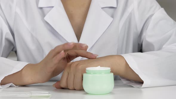 Closeup Scientist in White Coat Testing Cream with Active Natural Ingredients