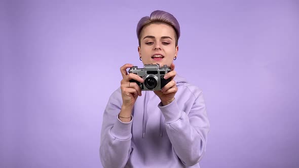 Young Person Taking Pictures Film Camera Isolated on Purple Indoors