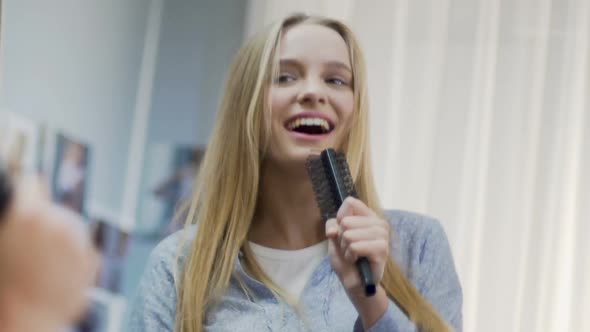 Pretty Girl Singing Playfully With Comb, Carefree Time, Reflection in Mirror