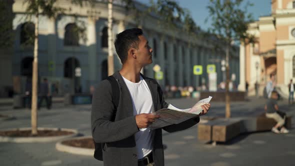 Real Time Portrait Shot of a Young Tourist Looking for Attractions with a Map in His Hands. Moscow