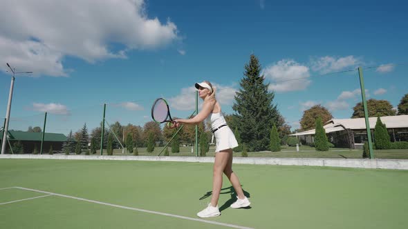 Professional Female Tennis Player Hits the Ball with a Racket Practice Game on the Tennis Court