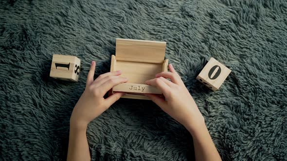 American Independence Day calendar blocks. Boy play with wooden block calendar.