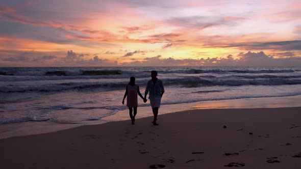 Couple Men and Woman Watching Sunset Sunset on the Beach of Phuket Thailand