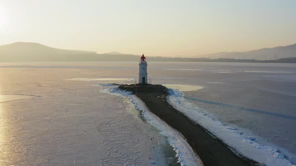 Flight Over the Frozen Sea and Drone View of Tokarevsky Lighthouse at Dawn