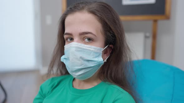 Brunette Little Person in Coronavirus Face Mask Looking at Camera with Serious Facial Expression