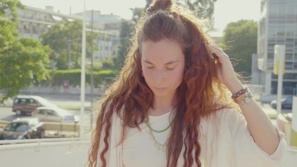 Slow motion shot of young woman with long brown hair in city