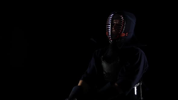 Masculine Kendo Warrior Practicing Martial Art with the Bamboo Bokken on Black Background. Slow